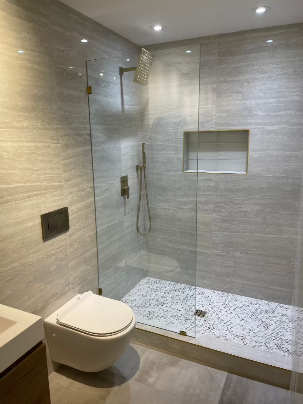 Grey stone walls, built-in wall shelf shower shelf, stainless stell shower faucet, floating toilet, digital tile, uniwue floor shower tiling, modern sink, modern bathroom remodel, Remodeling Source of San Diego, San Diego Remodel